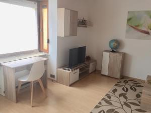 a living room with a desk and a television at Ferienwohnung Eva Maria in Pforzheim