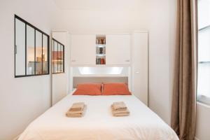 a bedroom with a bed with two towels on it at Le Laurencin Sens - La Verrière in Sens