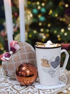 a cup of coffee and a christmas egg on a table at Teodor Chalet - Valea Avrigului in Avrig +60 photos