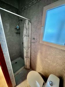 a bathroom with a shower and a toilet and a tub at Amplio con Patio y vistas a la Plaza in Dolores