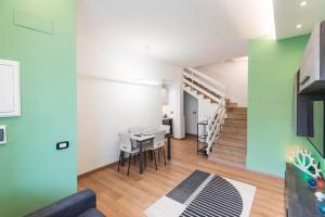 sala de estar con mesa y sillas y escalera en I Pumi Apartment & Free Parking - Lecce Selection, en Lecce