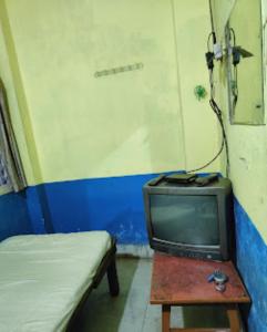 een kamer met een bed en een oude tv bij Hotel Ashray,Bhubaneswar in Bhubaneshwar