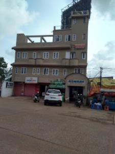een gebouw waar een auto voor geparkeerd staat bij Hotel Ashray,Bhubaneswar in Bhubaneshwar