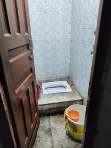 een kleine badkamer met een toilet in een stal bij Hotel Ashray,Bhubaneswar in Bhubaneshwar