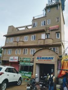 een witte truck geparkeerd voor een gebouw bij Hotel Ashray,Bhubaneswar in Bhubaneshwar