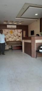 a man standing in a room with a bed at Hotel Bishram Bhawan,Bhubaneswar in Bhubaneshwar