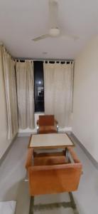 Habitación con mesa, 2 sillas y cortinas. en Hotel Bishram Bhawan,Bhubaneswar en Bhubaneshwar