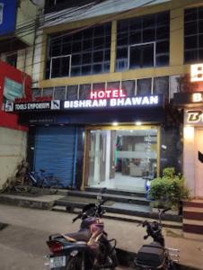 twee motorfietsen geparkeerd voor een hotel met een bord bij Hotel Bishram Bhawan,Bhubaneswar in Bhubaneshwar