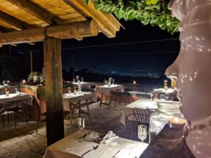 um restaurante com mesas e cadeiras à noite em PODERE DELL'ETNA SEGRETA - Essential Nature Hotel em Biancavilla