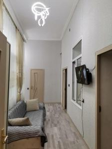 a living room with a couch and a tv at Eminera Hostels Baku in Baku