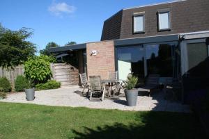 een patio met stoelen en een tafel voor een huis bij Liguster 56* in Nieuwvliet