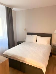 a bedroom with a large bed with white sheets at SUNSKII Apartments in Brzeće