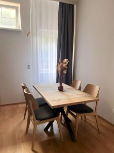 a wooden table with chairs and a vase with flowers on it at SUNSKII Apartments in Brzeće