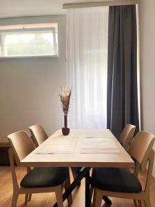 a table with chairs and a vase with flowers on it at SUNSKII Apartments in Brzeće