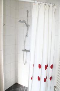 een douche met een douchegordijn met rode harten erop bij Liguster 56* in Nieuwvliet