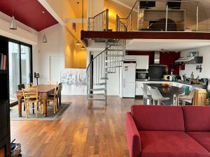 Un salón y una cocina con un sofá rojo y una mesa en Magnifique loft 130m2 Le Mans, en Le Mans