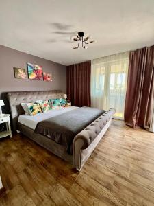 a bedroom with a large bed and a ceiling fan at Dominic Apartment Unirii Square in Timişoara
