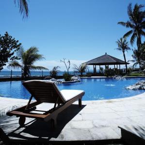 a lounge chair sitting next to a swimming pool at Villa Stefan in Pantai Anyer