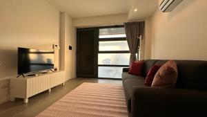 Una sala de estar con un sofá y un televisor. en CaseOspitali - Casa Navigli Watt, vicino al Naviglio, originale e luminoso bilocale per 4 con tutti i comfort, en Milán