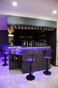 a bar with three bar stools and bottles of alcohol at Dimet Park Hotel in Van