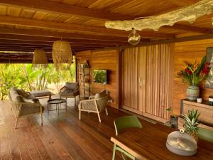 a living room with wooden walls and wooden floors at Kaya Lodge in Basse-Pointe