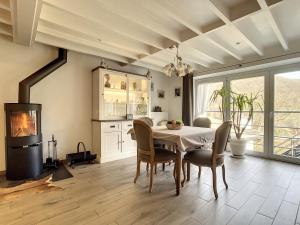 uma sala de jantar com uma mesa e cadeiras e uma lareira em Au Chat’Moineau em Aywaille