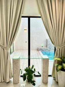 Habitación con mesa de cristal frente a una ventana en شاليهات بالما, en Al Hofuf
