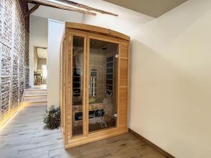 Habitación con un gran armario de madera con puertas de cristal. en Au Chat’Moineau, en Aywaille