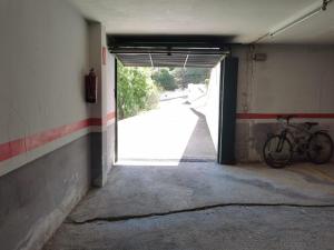 a bike parked in a garage with a door open at Apartamento Llançà, 2 dormitorios, 6 personas - ES-89-111 in Llança