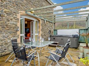 a patio with a table and chairs and a grill at 3 Bed in Builth Wells 52463 