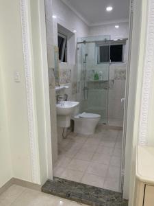 a bathroom with a shower and a toilet and a sink at Bếp Ông Tỏi Homestay in Ho Chi Minh City