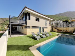 a house with a swimming pool and lawnitures at Miya del Sol Heated Saltwater Pool in La Orotava