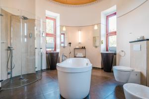 ein Bad mit einer Badewanne, 2 Waschbecken und einer Dusche in der Unterkunft Schloss Ranzow - Hotel & Appartements in Lohme