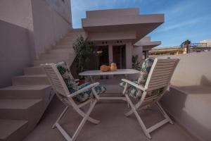 Arvacay Luxury Home في ماليا: كرسيين وطاولة على شرفة