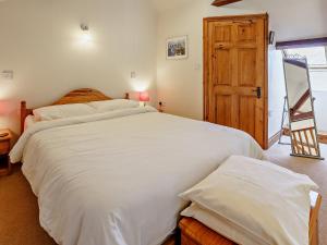 a bedroom with a large bed and a wooden door at 1 Bed in Nantgaredig 51499 in Llanfynydd