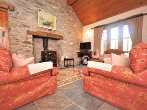 - un salon avec deux canapés et une cheminée en pierre dans l'établissement 2 Bed in Trefin 53019, à Trevine