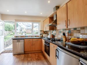 een keuken met houten kasten en roestvrijstalen apparatuur bij 3 Bed in Brixham BX001 in Brixham