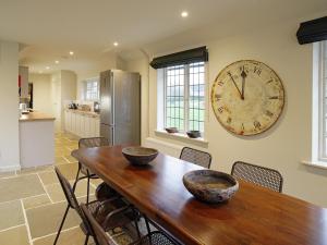 a dining room table with two bowls on it with a clock on the wall at 3 Bed in Eastbourne 57383 in Alfriston