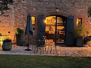 a patio with chairs and umbrellas in a brick building at Le Clos de Mara in Issus