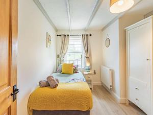 a bedroom with a bed with yellow sheets and a window at 3 Bed in Northumberland National Park CN039 in Alwinton