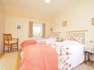 a bedroom with two beds and a chair at 2 Bed in Carnoustie 58026 in Monikie