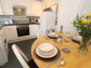 a kitchen with a wooden table with plates on it at 2 Bed in Alnwick CN101 in Alnwick