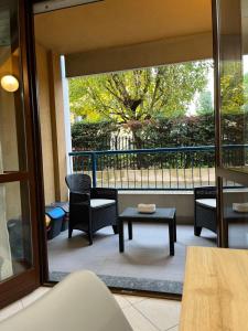 eine Terrasse mit Stühlen, einem Tisch und einem Fenster in der Unterkunft Elegante Casa -Rho Fiera in Vanzago