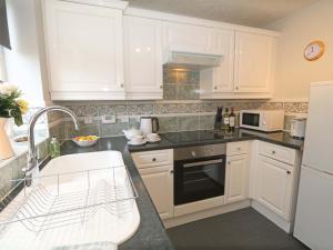 a kitchen with white cabinets and a sink at 2 Bed in Alnwick CN101 in Alnwick