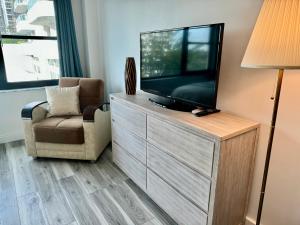 een woonkamer met een flatscreen-tv en een stoel bij Directly on the Beach with Pool & Parking in Miami Beach
