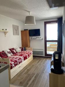 a bedroom with a bed and a large window at Samoëns 1600 studio au pied des pistes in Samoëns
