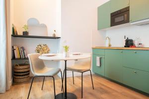 a kitchen with a table and chairs in a kitchen at Le Laurencin Sens - Le Zen in Sens