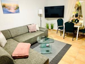 a living room with a couch and a table at Souterrain Monteurwohnung mit Sauna und Garten in Rostock
