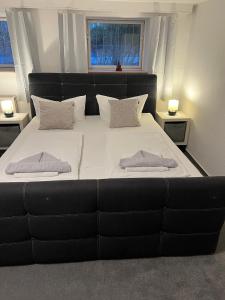a large black bed with two pillows on it at Souterrain Monteurwohnung mit Sauna und Garten in Rostock