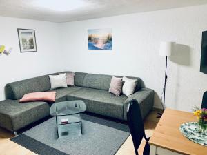 a living room with a couch and a table at Souterrain Monteurwohnung mit Sauna und Garten in Rostock +5 photos